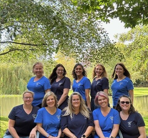 A group photo of women Bookkeepers and Accountants infront of a lake.
