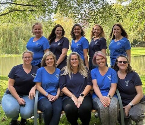 A group photo of women Bookkeepers and Accountants infront of a lake.